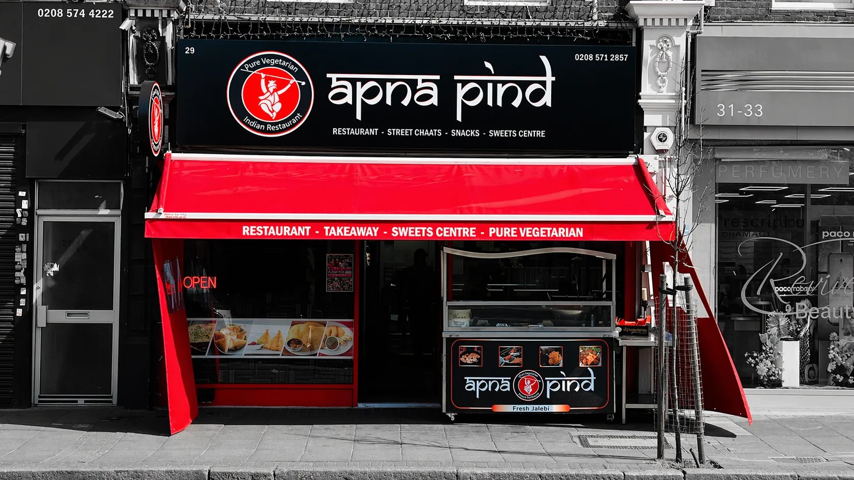 The Apna Pind storefront on King Street, Southall — a red awning below a black sign.